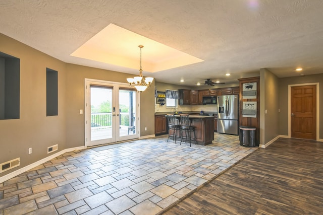 1888 S High Rdg, Nixa, MO 65714 - kitchen featuring stainless steel fridge, baseboards, black microwave, a breakfast bar area, and a textured ceiling
