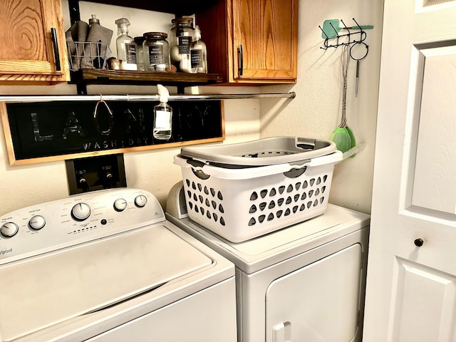64 Deer Park Cir, Kimberling City, MO 65686 - clothes washing area featuring washer and clothes dryer, cabinet space, and a textured wall