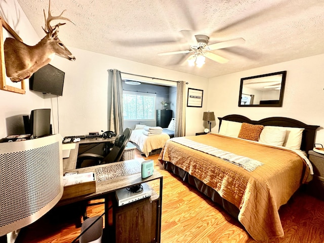 64 Deer Park Cir, Kimberling City, MO 65686 - bedroom with light wood-type flooring, a textured ceiling, a desk, and a ceiling fan
