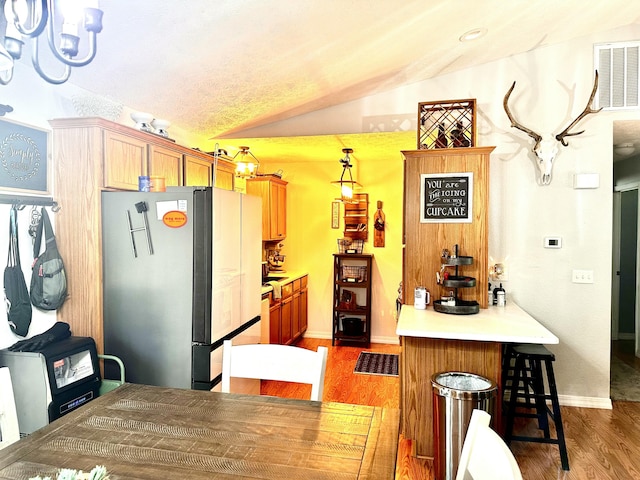 64 Deer Park Cir, Kimberling City, MO 65686 - kitchen with freestanding refrigerator, vaulted ceiling, wood finished floors, a breakfast bar area, and a peninsula