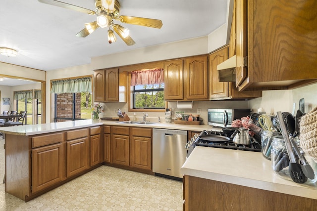1065 Nicks Rd, Bradleyville, MO 65614 - kitchen with stainless steel appliances, a sink, a peninsula, and brown cabinetry