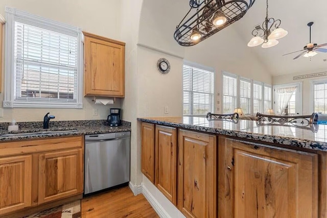 kitchen with dishwasher, a sink, vaulted ceiling, light wood-style floors, and a ceiling fan