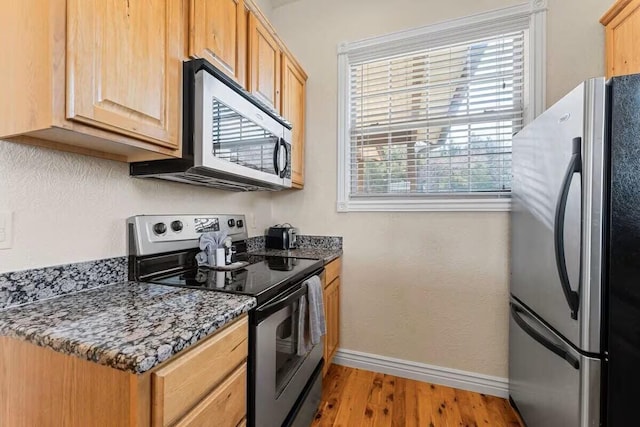 kitchen featuring appliances with stainless steel finishes, baseboards, light wood-style floors, and light brown cabinetry