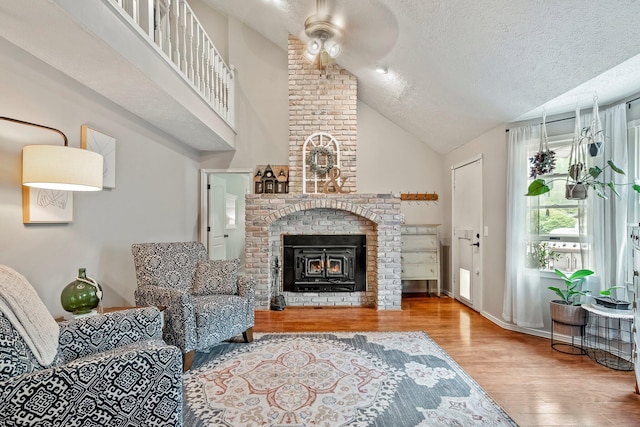 178 S Peach Tree Ln, Republic, MO 65738 - living room featuring a brick fireplace, wood finished floors, a ceiling fan, lofted ceiling, and a textured ceiling
