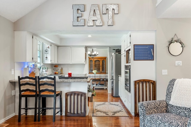 178 S Peach Tree Ln, Republic, MO 65738 - kitchen with appliances with stainless steel finishes, a peninsula, dark wood-style floors, a sink, and white cabinetry