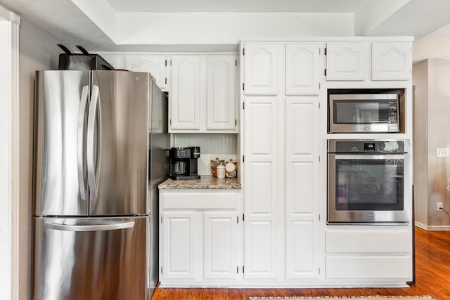 178 S Peach Tree Ln, Republic, MO 65738 - kitchen featuring stainless steel appliances, white cabinetry, light stone counters, and wood finished floors