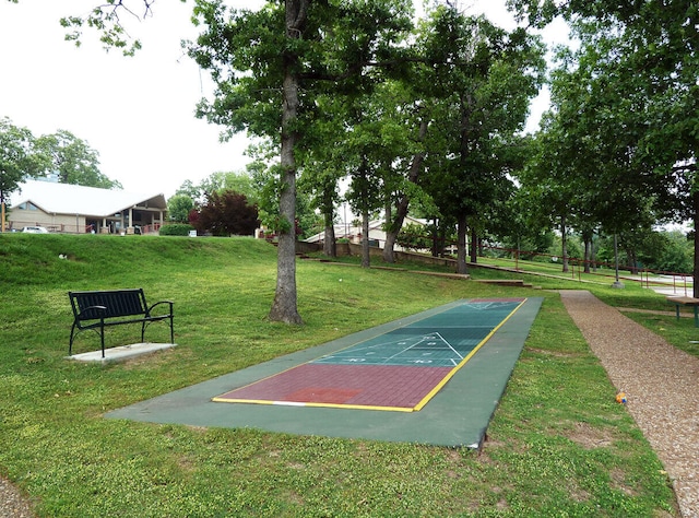 view of community featuring shuffleboard and a lawn