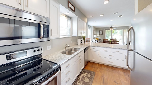 kitchen with appliances with stainless steel finishes, a sink, ceiling fan, white cabinetry, and recessed lighting