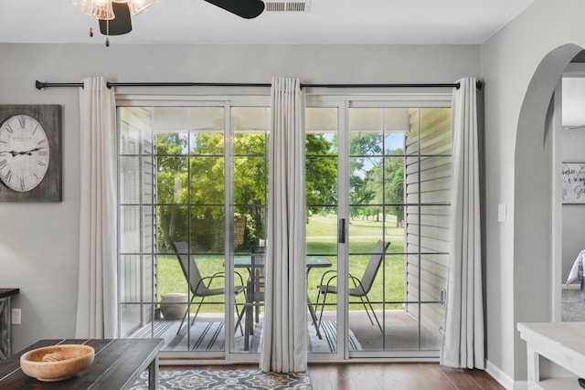 entryway featuring arched walkways, a ceiling fan, and wood finished floors