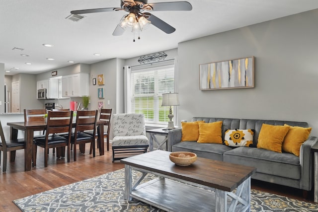living room featuring wood finished floors, a ceiling fan, and recessed lighting