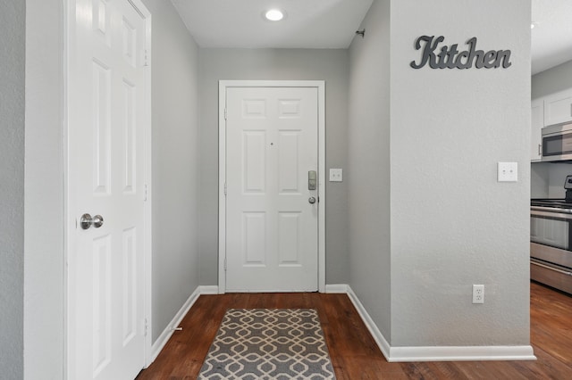 doorway to outside featuring dark wood-type flooring, baseboards, and recessed lighting