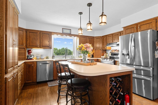 77 Johnson Way Ln, Kimberling City, MO 65686 - kitchen with stainless steel appliances, light countertops, a center island, a sink, and brown cabinets