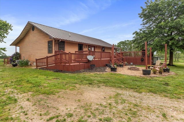 6203 County Road 1750, West Plains, MO 65775 - back of property with an outdoor fire pit, a wooden deck, a standing seam roof, a yard, and metal roof