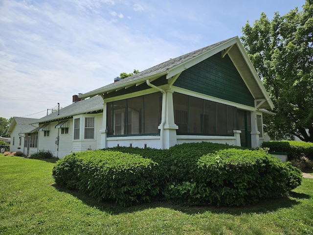 view of home's exterior with a yard and a sunroom