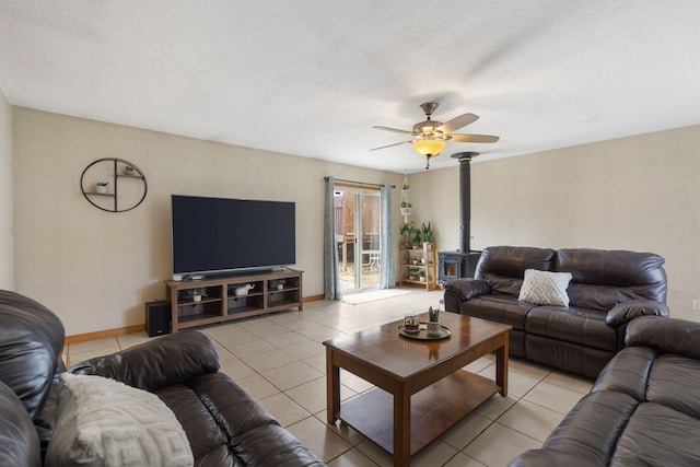 living area featuring light tile patterned flooring, a ceiling fan, and baseboards