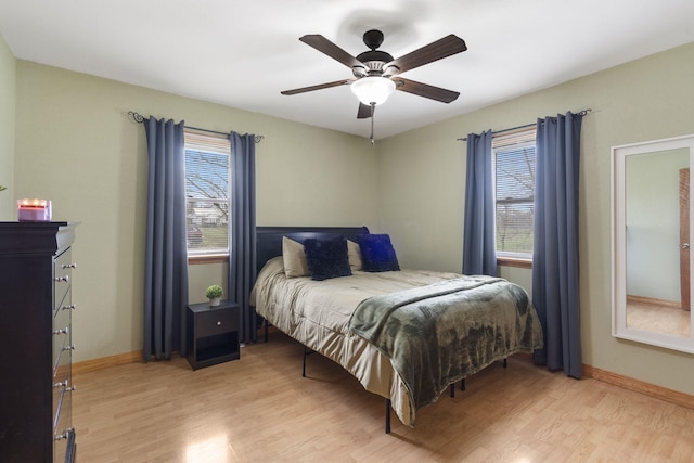 bedroom featuring light wood finished floors, baseboards, and ceiling fan