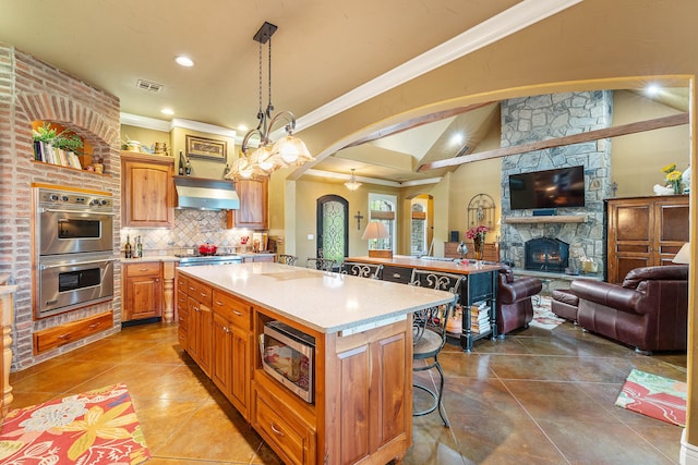 315 Buckskin Rdg, Pineville, MO 64856 - kitchen with stainless steel appliances, arched walkways, open floor plan, ventilation hood, and a center island