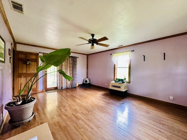 spare room with ornamental molding, a ceiling fan, wood finished floors, and baseboards
