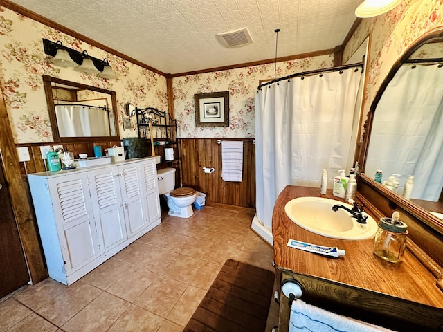 full bath featuring wallpapered walls, crown molding, a wainscoted wall, toilet, and vanity
