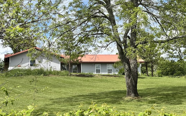 view of front facade with a front yard and metal roof