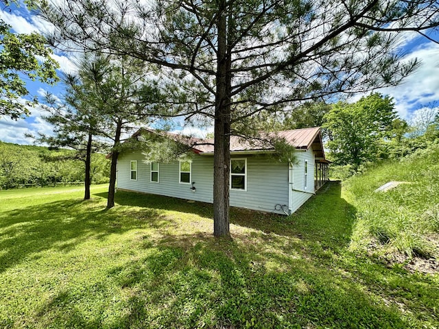 view of property exterior featuring a yard and metal roof