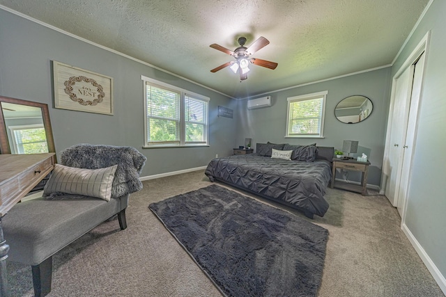 carpeted bedroom featuring crown molding, a textured ceiling, a wall mounted AC, a ceiling fan, and baseboards