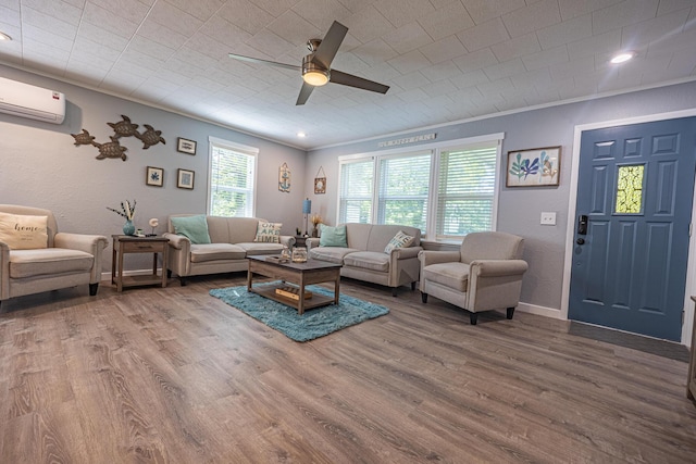 living room with wood finished floors, a ceiling fan, a wall mounted air conditioner, baseboards, and recessed lighting