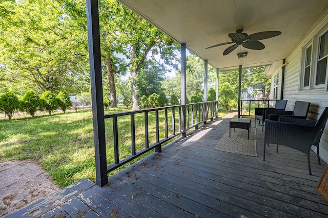 deck featuring ceiling fan and a lawn
