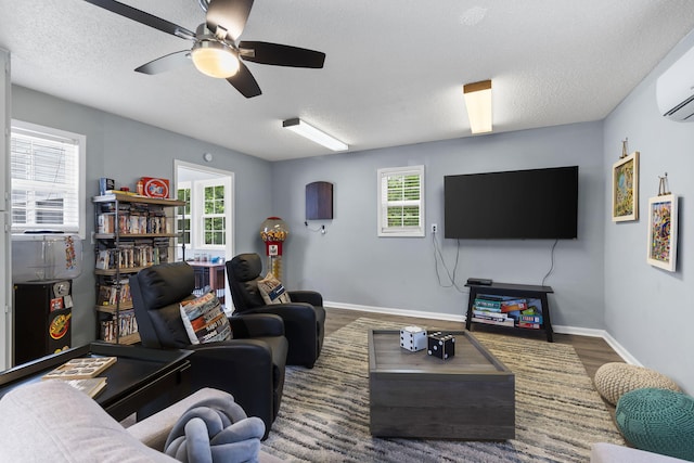 26478 Shadow Rd, Pittsburg, MO 65724 - living room featuring ceiling fan, a textured ceiling, wood finished floors, baseboards, and a wall mounted AC