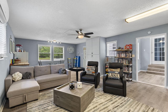 26478 Shadow Rd, Pittsburg, MO 65724 - living room featuring a textured ceiling, ceiling fan, wood finished floors, an AC wall unit, and stairway