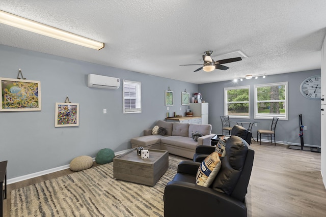 26478 Shadow Rd, Pittsburg, MO 65724 - living room with a wall mounted AC, a ceiling fan, wood finished floors, a textured ceiling, and baseboards