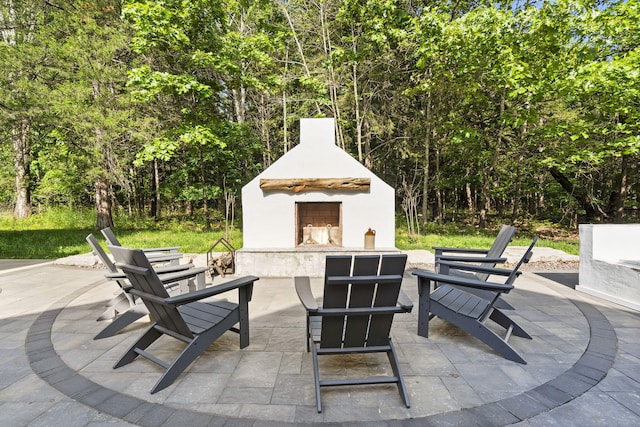 452 Rest Haven Ln, Blue Eye, MO 65611 - view of patio with exterior fireplace and a forest view