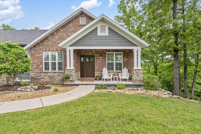 103 Dogwood Ct, Saddlebrooke, MO 65630 - craftsman-style house featuring covered porch, a front lawn, brick siding, and stone siding