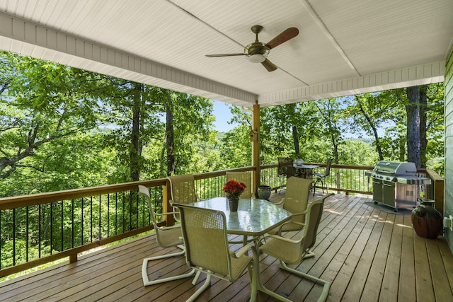 103 Dogwood Ct, Saddlebrooke, MO 65630 - wooden deck with outdoor dining area, ceiling fan, view of wooded area, and area for grilling
