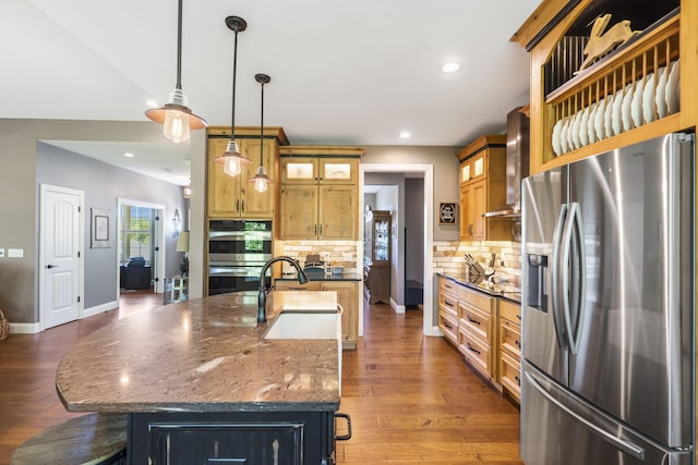 103 Dogwood Ct, Saddlebrooke, MO 65630 - kitchen featuring appliances with stainless steel finishes, a sink, tasteful backsplash, a breakfast bar area, and wall chimney range hood