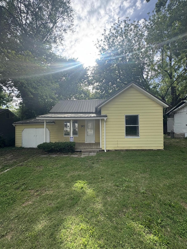 2007 N Travis Ave, Springfield, MO 65803 - back of property with covered porch, a yard, and metal roof