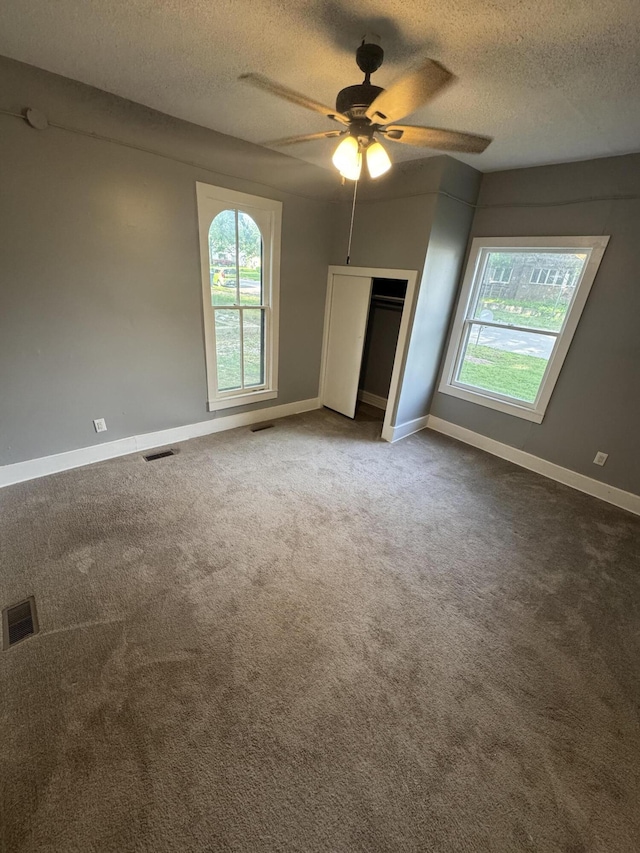 2007 N Travis Ave, Springfield, MO 65803 - unfurnished bedroom featuring a textured ceiling, multiple windows, carpet floors, and baseboards