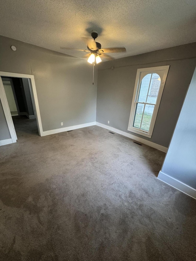 2007 N Travis Ave, Springfield, MO 65803 - spare room with a ceiling fan, a textured ceiling, dark colored carpet, and baseboards