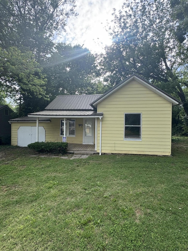 2007 N Travis Ave, Springfield, MO 65803 - rear view of house featuring a lawn, covered porch, metal roof, and a shed