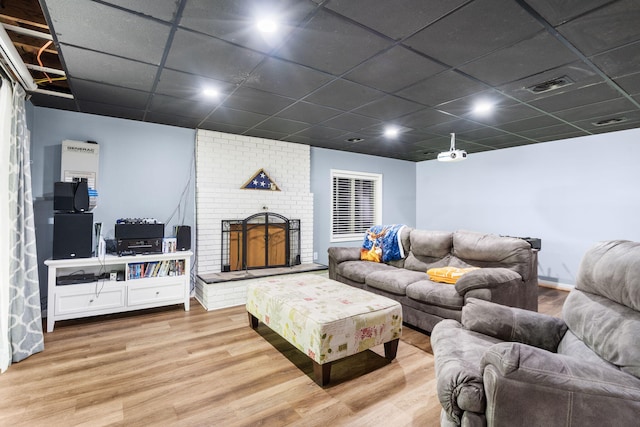 3662 N Farm Rd Unit 127, Springfield, MO 65803 - living room featuring wood finished floors, a brick fireplace, and a drop ceiling