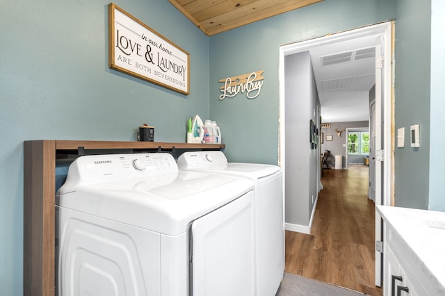 3662 N Farm Rd Unit 127, Springfield, MO 65803 - washroom featuring washer and dryer, dark wood finished floors, wooden ceiling, and baseboards