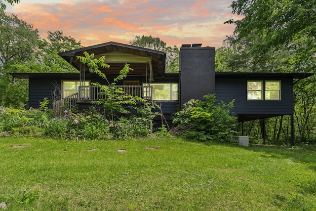 3662 N Farm Rd Unit 127, Springfield, MO 65803 - back of house at dusk with a chimney, a yard, and a wooden deck