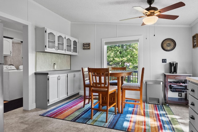 dining room featuring independent washer and dryer, crown molding, a ceiling fan, and a textured ceiling