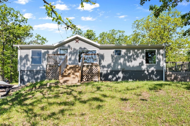 manufactured / mobile home featuring a deck and a front lawn