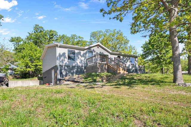 view of front of house with a wooden deck and a front lawn