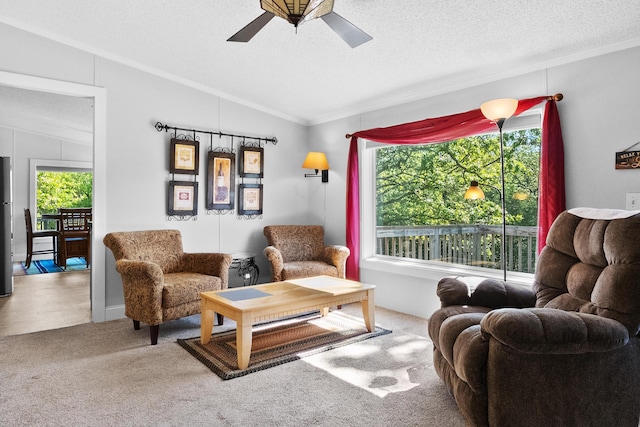 carpeted living room with crown molding, a ceiling fan, vaulted ceiling, and a textured ceiling
