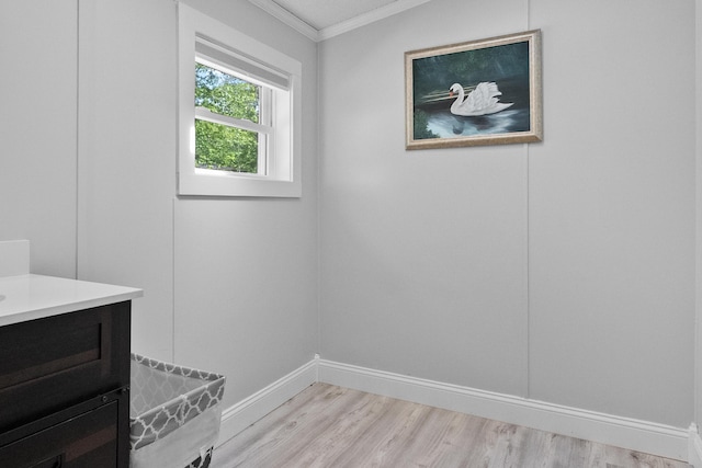 bathroom featuring crown molding, wood finished floors, baseboards, and vanity
