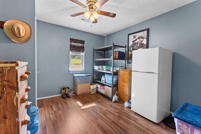 229 Grand Slam Ave, Cape Fair, MO 65624 - bedroom featuring freestanding refrigerator, wood finished floors, a textured ceiling, baseboards, and a ceiling fan