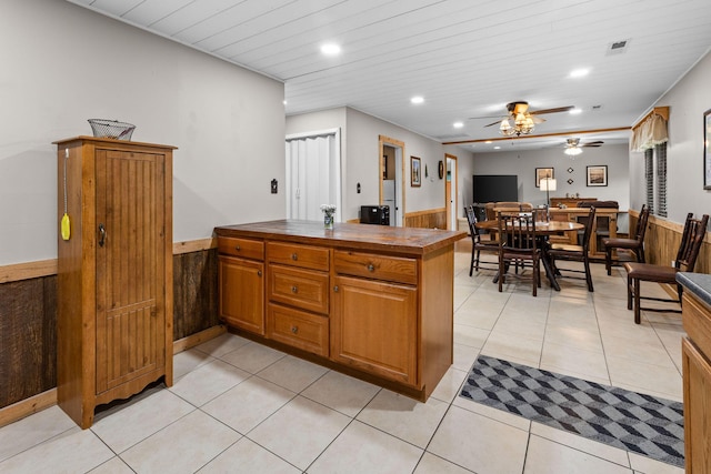 229 Grand Slam Ave, Cape Fair, MO 65624 - kitchen with a peninsula, ceiling fan, recessed lighting, brown cabinetry, and a wainscoted wall
