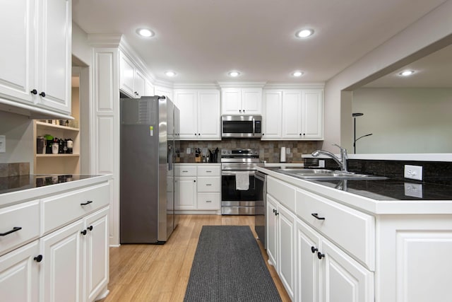 700 E Delmar St, Springfield, MO 65807 - kitchen featuring stainless steel appliances, a sink, light wood finished floors, white cabinetry, and recessed lighting